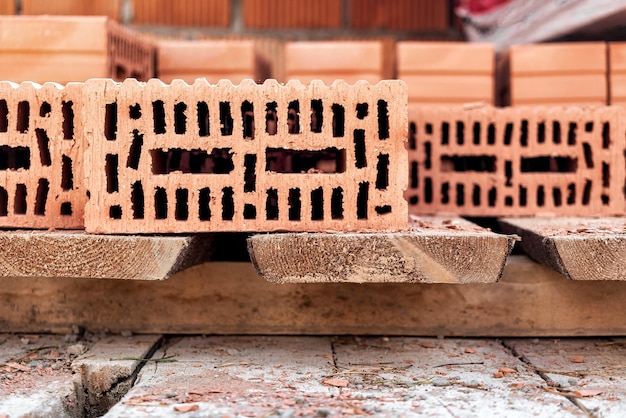 Red ceramic bricks at the construction site Keramoblock Hollow brick Construction of a red brick building Closeup Material for the construction of walls and partitions