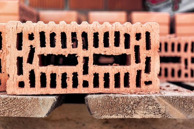 Red ceramic bricks at the construction site Keramoblock Hollow brick Construction of a red brick building Closeup Material for the construction of walls and partitions