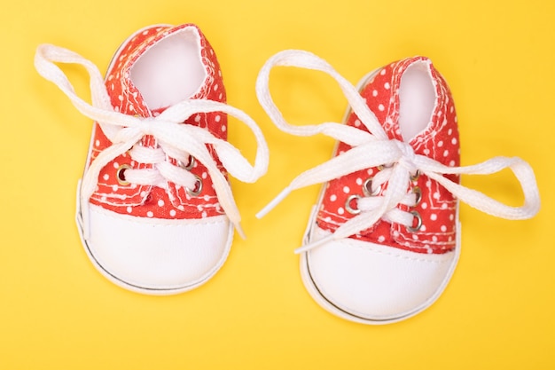 Red children's boots with white polka dots on yellow