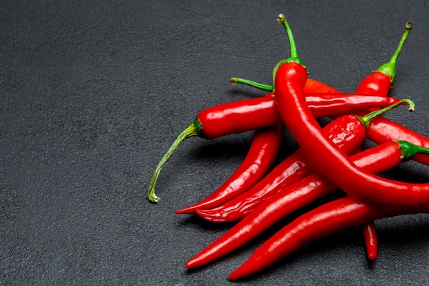 Red chili pepper on dark concrete background