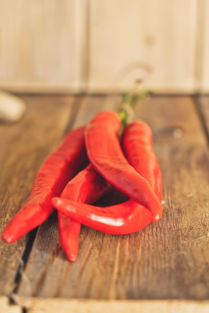 Red chili pepper pods on a wooden background