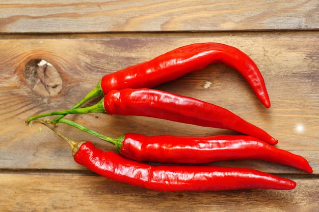 Red chili pepper pods on a wooden background