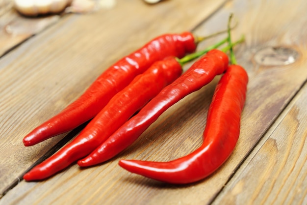 Red chili pepper pods on a wooden background