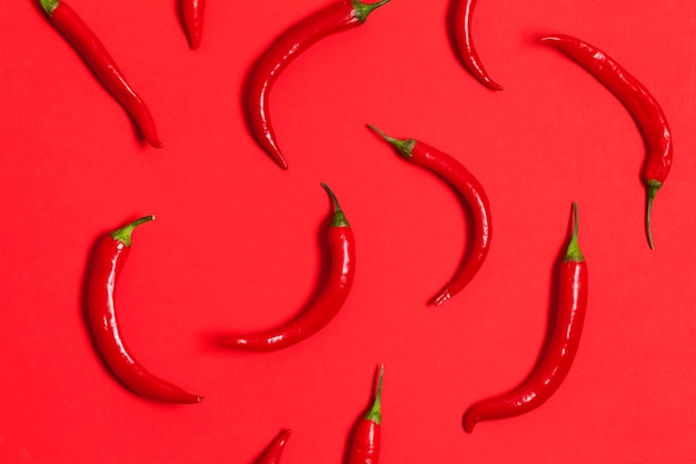 Red chili peppers arranged on a bright red background