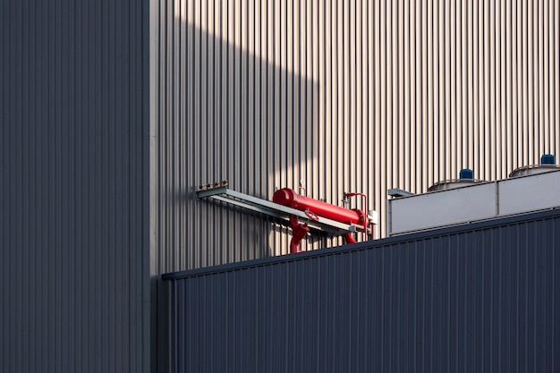 Red chiller with compressors of air conditioners system on top of black modern industrial building