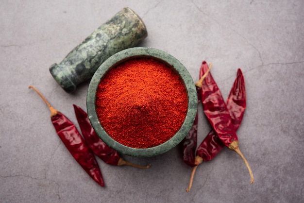 Red Chilli or Lal Mirchi or mirch with Powder in a bowl or mortar over moody background, selective focus