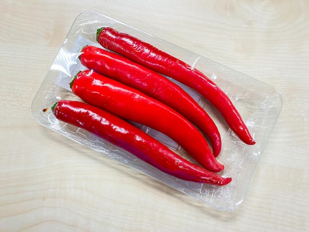 Red chilli spur peppers in plastic pack on the table