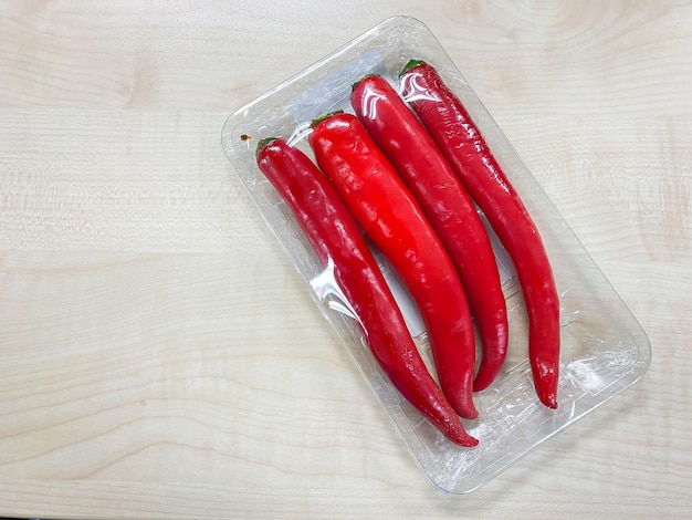 Red chilli spur peppers in plastic pack on the table