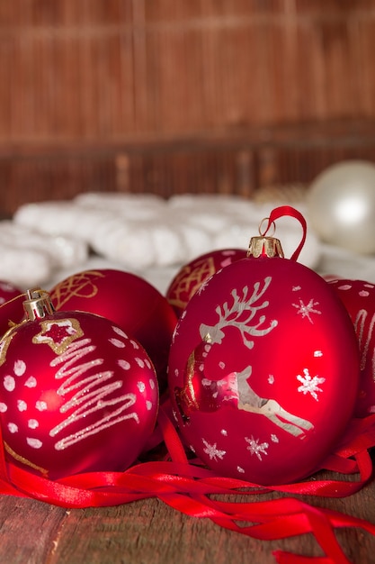 Red Christmas ball and ribbons on wooden background