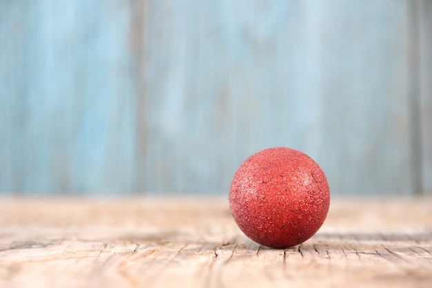 Red Christmas ball on wood table background