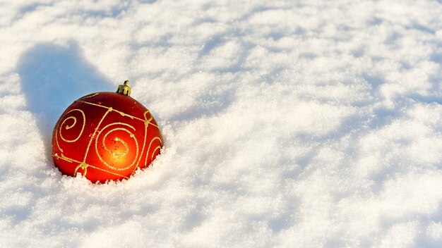 Red christmas balls in the snow on white.