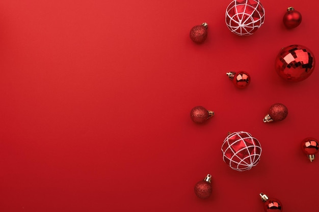 Red Christmas baubles decoration on red background with copy space flat lay