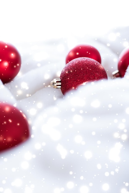 Red Christmas baubles on fluffy fur with snow glitter luxury winter holiday design background