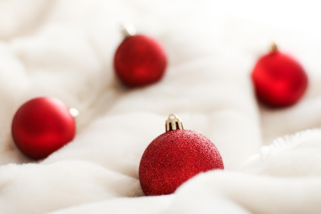 Red Christmas baubles on white fluffy fur backdrop luxury winter holiday design background