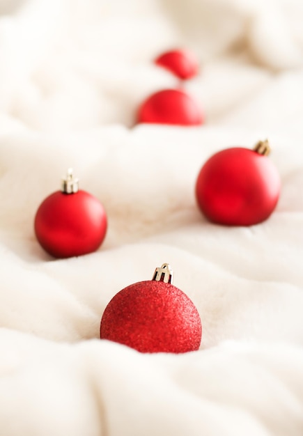 Red Christmas baubles on white fluffy fur backdrop luxury winter holiday design background