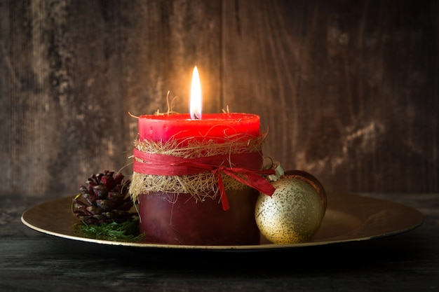 Red Christmas candle and Christmas ornaments on wood