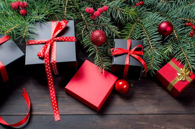 Red christmas  gift  box with red ribbon and fir branches