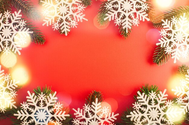 Red Christmas holidays background; greeting card , Christmas card with fir and decor on glitter background