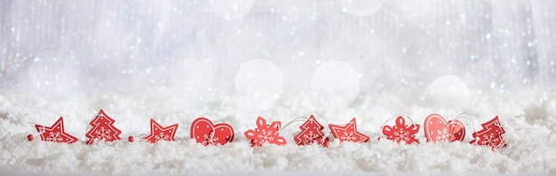 Red Christmas ornaments row on Christmas snowy bokeh background