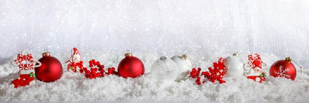 Red Christmas ornaments row on Christmas snowy bokeh background