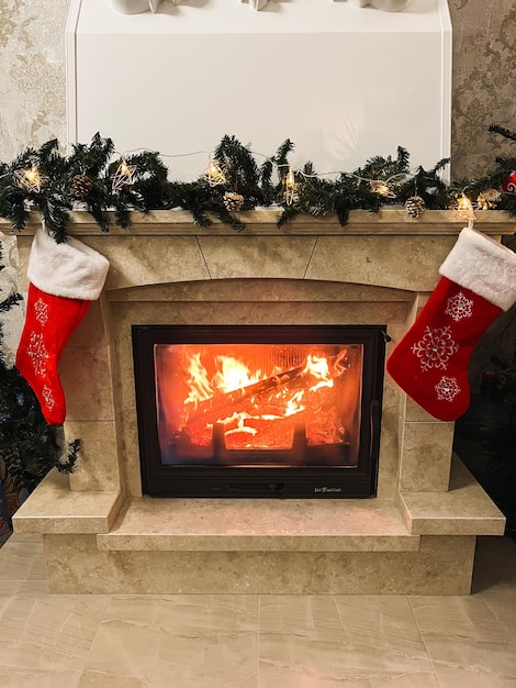 Red Christmas socks for gifts were hung over the lit fireplace Preparing for the New year