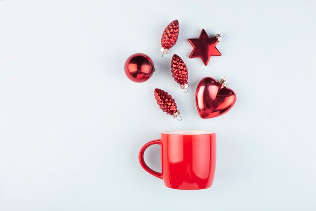 red Christmas toys from a red cup on a blue, top view