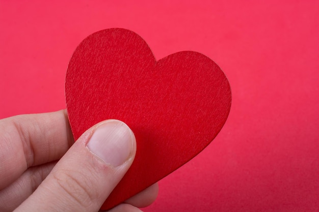 Red color heart shaped object in hand