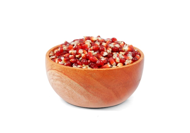 Red corn in a wooden bowl isolated on a white background