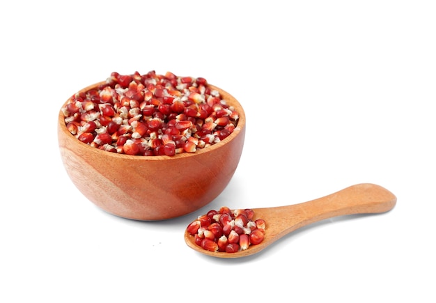 Red corn in wooden bowl and wooden spoon isolated on white background