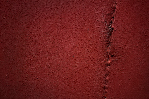 Red cracked paint on a metal door Background texture