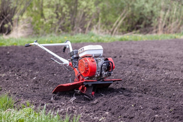 Red cultivator cultivates a vegetable garden for planting vegetables and potatoes