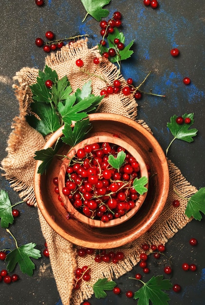 Red currants in bowl in the heart shape food background top view