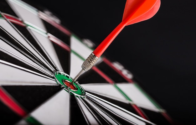 Red dart arrow on center of dartboard. Concept of business target, success and win.