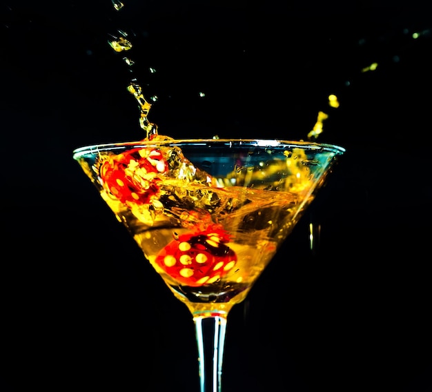 red dice falling into full cocktail glass