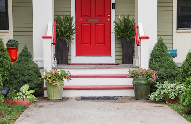 A red door with flowers on the front steps.