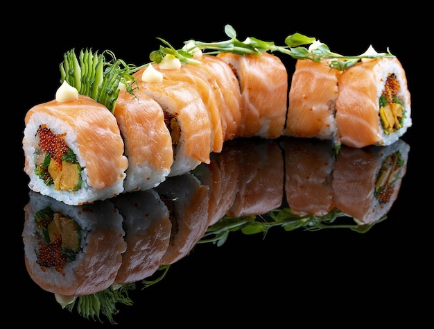 Red Dragon roll with salmon avocado and tobiko on glossy black background