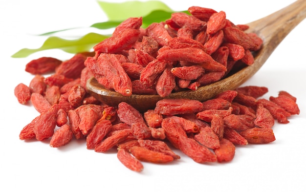 Red dried goji berries in wooden spoon