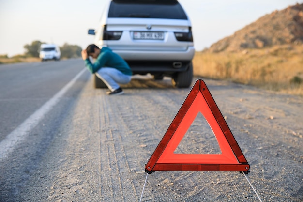 Red emergency stop sign and broken silver car