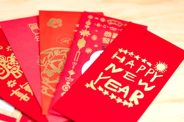 Red envelope packet chinese new year, hongbao with the character 'Happy New Year' on wood background for Chinese New Year. Translation: Good luck in the year