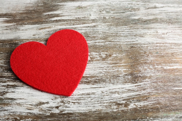 Red felt heart on grey wooden background