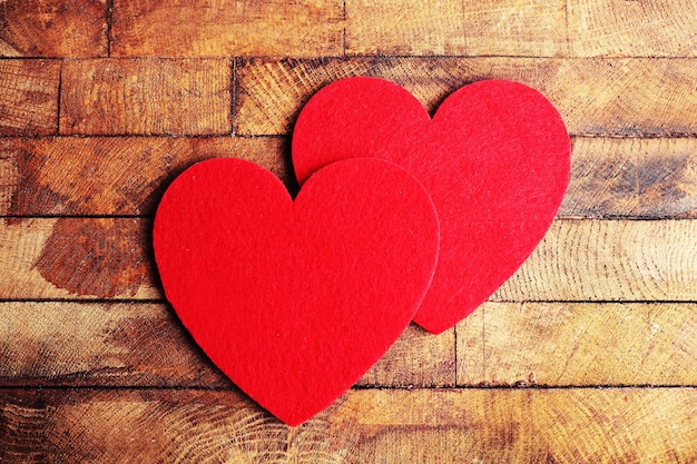 Red felt hearts on wooden background