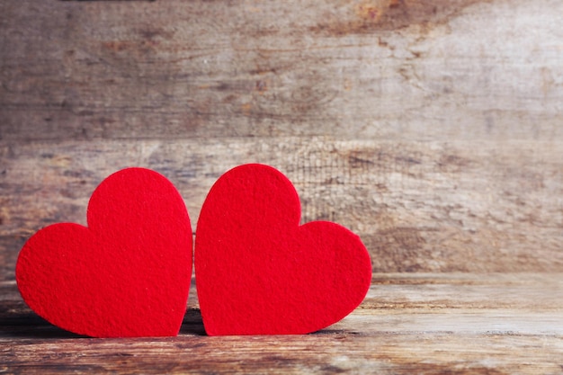 Red felt hearts on wooden background