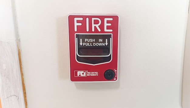 A red fire alarm with a red button on it