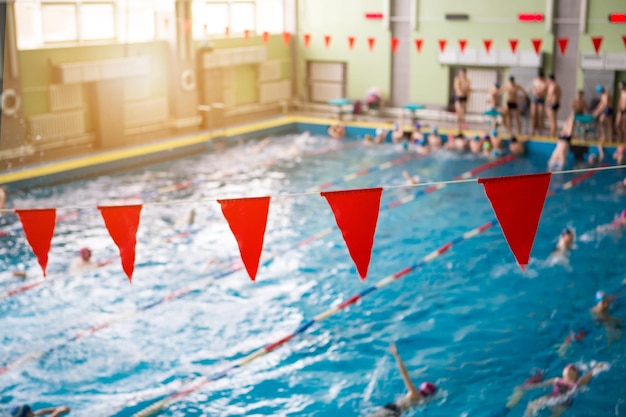 Red flags hanging in the pool at the competition. The concept of sport and health.