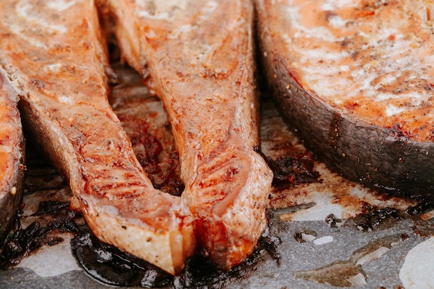 Red fried fish steaks. Baked salmon pieces. Juicy appetizing salmon lies on baking sheet. Healthy food concept