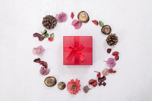 Red gift box in Christmas round frame made of natural winter things