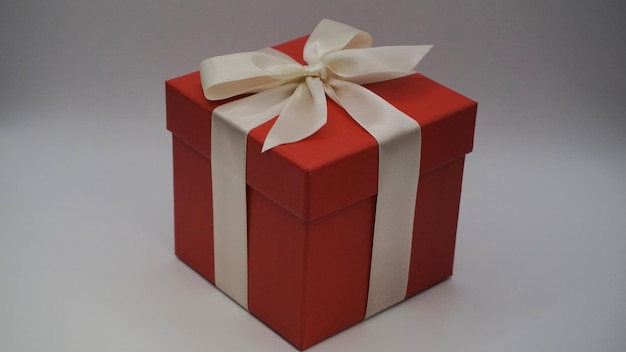 Red gift box tied with white ribbon and blank space