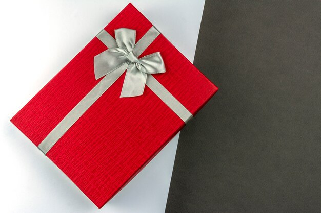 Red gift box with bow white and grey background