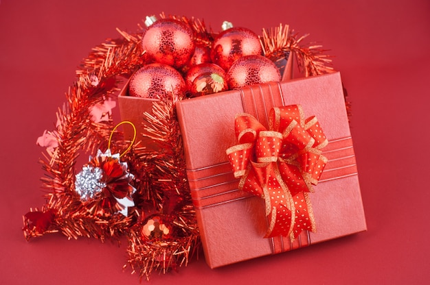 Red Gift Box with Decorations on Red background. Christmas Holiday Concept