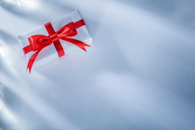 Red gift box with tied bow on white background